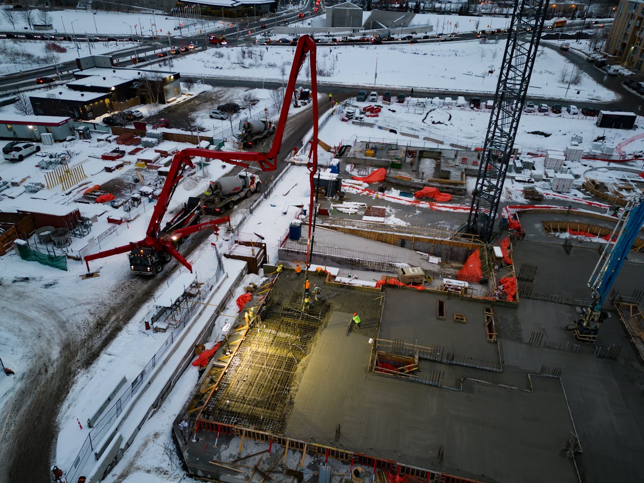 Drone shot of a snowy construction site with heavy machinery in Ottawa, Canada.